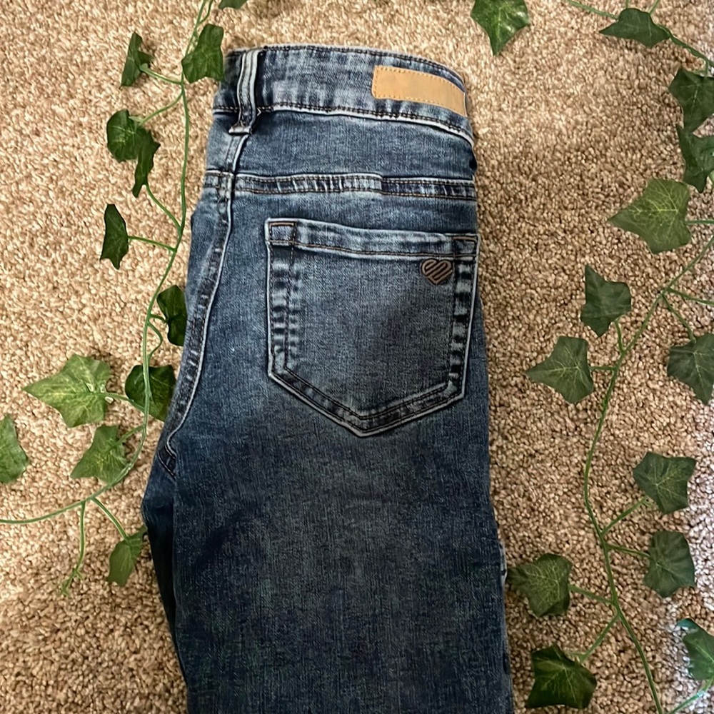 Justice dark wash jeans with acid wash out-lines.